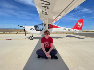 Lukas seated by an aircraft